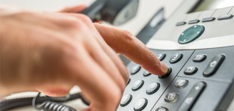 Closeup of male hand dialing a phone number making a business or personal phone call.